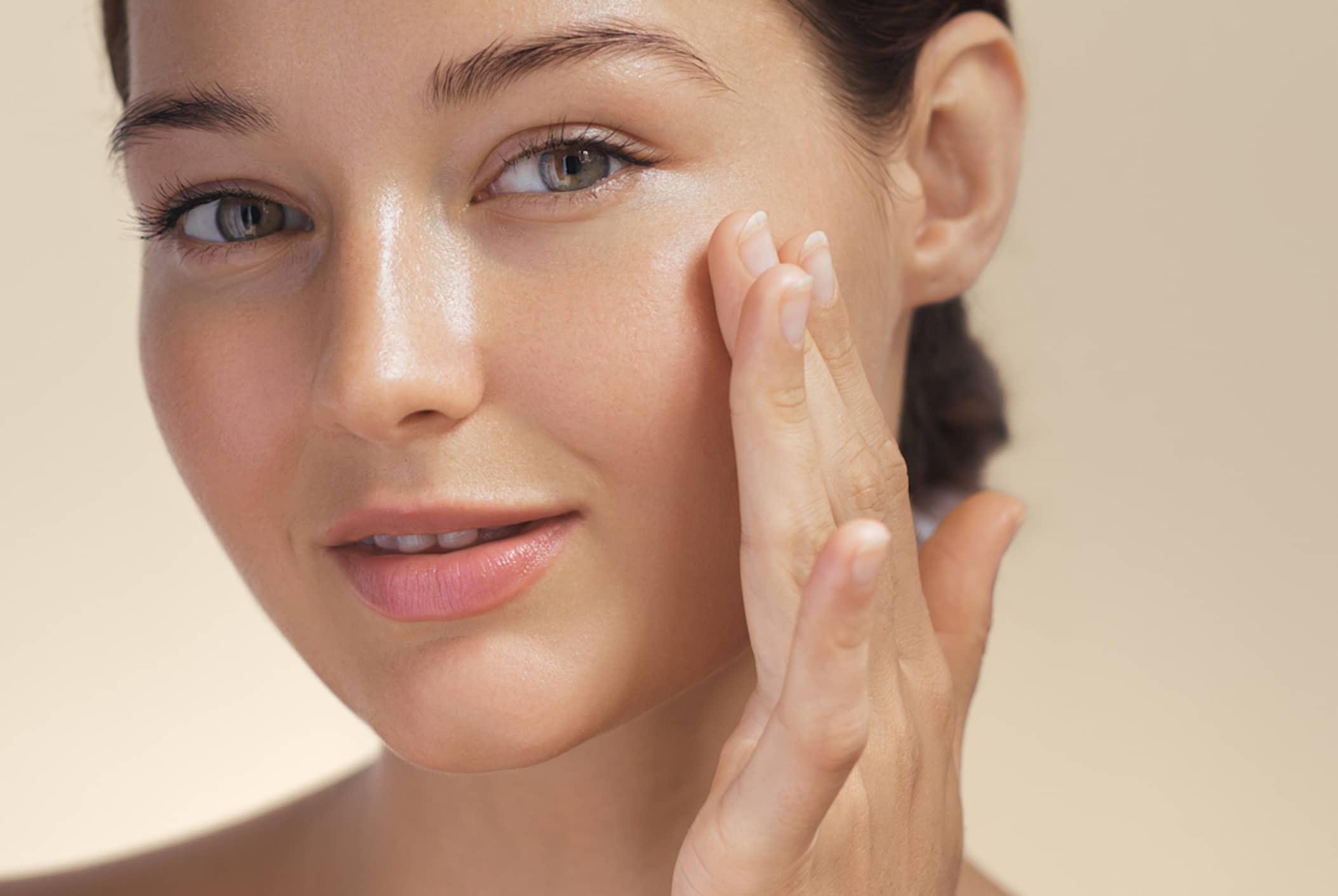 Woman with beautiful face touching healthy facial skin portrait.
